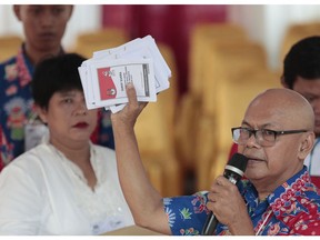 An electoral worker shows ballots during the election at a polling station in Jakarta, Indonesia, Wednesday, April 17, 2019. Voting is underway in Indonesia's presidential and legislative elections after a campaign that that pitted the moderate incumbent against an ultra-nationalist former general.