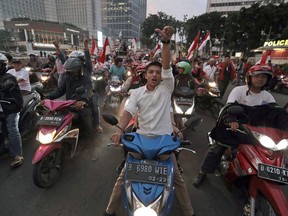 Supporters of Indonesian President Joko Widodo celebrate during a rally in Jakarta, Indonesia, Wednesday, April 17, 2019. Widodo is on track to win a second term, preliminary election results showed Wednesday, in apparent victory for moderation over the ultra-nationalistic rhetoric of his rival Prabowo Subianto.