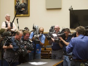 Photojournalists photograph four pages of report by special counsel Robert Mueller on the witness table in the House Intelligence Committee hearing room on Capitol Hill, in Washington, Thursday, April 18, 2019.