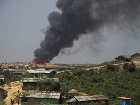 Smoke and flames rise from the site of a fire at  the Kutupalong refugee camp in Cox's Bazar, Bangladesh, Wednesday, April 24, 2019. A fire raced through a sprawling camp of Rohingya refugees in southern Bangladesh, destroying more than two dozen huts and a mosque on Wednesday, an official said. (AP Photo)