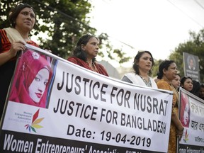 Protesters hold placards and gather to demand justice for an 18-year-old woman who was killed after she was set on fire for refusing to drop sexual harassment charges against her Islamic school's principal, in Dhaka, Bangladesh, Friday, April 19, 2019. Nusrat Jahan Rafi told her family she was lured to the roof of her rural school in the town of Feni on April 6 and asked to withdraw the charges by five people clad in burqas. When she refused, she said her hands were tied and she was doused in kerosene and set alight. Rafi told the story to her brother in an ambulance on the way to the hospital and he recorded her testimony on his mobile phone. She died four days later in a Dhaka hospital with burns covering 80% of her body.