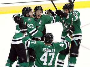 Dallas Stars' Esa Lindell (23), Alexander Radulov (47) and Tyler Seguin (91) celebrate with John Klingberg, center, who scored in overtime against the Nashville Predators in Game 6 of an NHL hockey first-round playoff series in Dallas, Monday, April 22, 2019. The Stars won 2-1 in overtime.