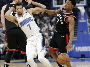 Orlando Magic's Michael Carter-Williams, left, and Toronto Raptors' Kyle Lowry collide during the first half in Game 3 of a first-round NBA basketball playoff series, Friday, April 19, 2019, in Orlando, Fla.