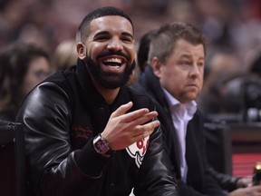 Drake smiles as he watches the Toronto Raptors play the Golden State Warriors during first half NBA basketball action in Toronto on Thursday Nov. 29, 2018.