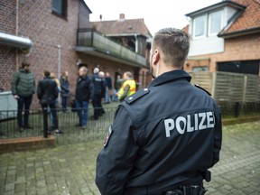 FILE -- A police officer attends a raid against fraud crime in Wriedel, Germany, Wednesday, March 27, 2019. New government statistics show overall crime in Germany, including violent offenses, dropped in 2018 while clearance rates continue to climb German Interior Minister Horst Seehofer said on Tuesday.