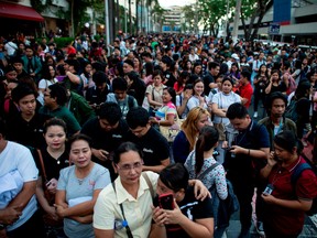 Employees are seen at an open area in Manila, after an earthquake rocked the Philippines on April 22, 2019. - A powerful earthquake rocked the Philippines, sending thousands of people fleeing high-rises in Manila as buildings shook. Office workers piled out onto the streets as emergency alarms blared, AFP reporters saw, but there were no immediate reports of injuries or damage.