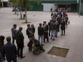 People line up outside a polling station to cast their vote for the general election in Barcelona, Spain, Sunday, April 28, 2019. Galvanized by the Catalan crisis, Spain's far right is set to enter Parliament for the first time in decades while the Socialist government tries to cling on to power in Spain's third election in four years.