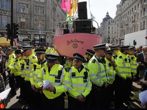 Police forces surround a boat at Oxford Circus in London, Friday, April 19, 2019. The group Extinction Rebellion is calling for a week of civil disobedience against what it says is the failure to tackle the causes of climate change.