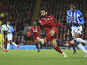 Liverpool's Mohamed Salah shoots on goal during the English Premier League soccer match between Liverpool and Huddersfield Town at Anfield Stadium, in Liverpool, England, Friday, April 26, 2019.