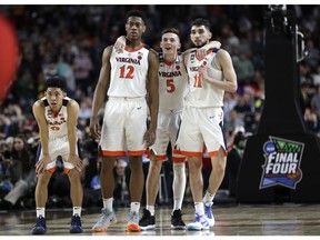 Virginia players Kihei Clark, from left, De'Andre Hunter, Kyle Guy and Ty Jerome celebrate at the end of the championship game against Texas Tech in the Final Four NCAA college basketball tournament, Monday, April 8, 2019, in Minneapolis. Virginia won 85-77 in overtime.