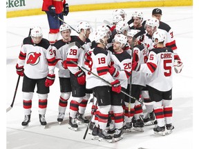 Teammates congratulate New Jersey Devils center Travis Zajac (19) after he scored the game winning goal against the Florida Panthers during the overtime period of an NHL hockey game, Saturday, April 6, 2019, in Sunrise, Fla. The Devils defeated the Panthers 4-3 in overtime.