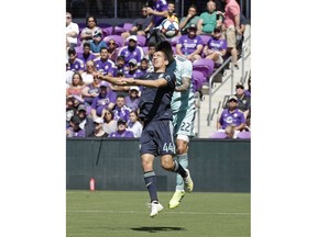 Orlando City's Joao Moutinho (44) goes up against Vancouver Whitecaps' Erik Godoy (22) for a header during the first half of an MLS soccer match, Saturday, April 20, 2019, in Orlando, Fla.