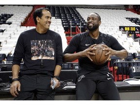 Miami Heat head coach Erik Spoelstra, left, talks with guard Dwyane Wade, before a game against the Philadelphia 76ers, Tuesday, April 9, 2019, in Miami. Wade is playing his final home regular season game before retiring at the end of the season.
