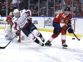 Florida Panthers defenseman Mark Pysyk (13) skates with the puck as Washington Capitals right wing T.J. Oshie (77) defends during the first period of an NHL hockey game, Monday, April 1, 2019, in Sunrise, Fla.