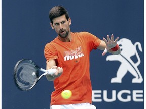 FILE - In this March 18, 2019, file photo, Novak Djokovic hits during a practice round for the Miami Open tennis tournament at Hard Rock Stadium in Miami Gardens, Fla. As Djokovic begins his preparations for a fourth straight Grand Slam title, he likes to imagine beating Rafael Nadal in the French Open final.