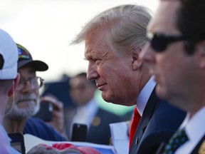 President Donald Trump leans in to listen to his supporters on the tarmac upon his arrival at Palm Beach International Airport, Thursday, April 18, 2019, in West Palm Beach, Fla. Trump traveled to Florida to spend the Easter weekend as his Mar-a-Lago estate.