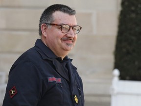 Chaplain of the Paris Fire Department, Jean-Marc Fournier, right, walks down the steps of the Elysee Palace in Paris after a meeting with French President Emmanuel Macron, Thursday, April 18, 2019.