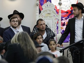 Almog Peretz, center, sits near his niece, Noya Dahan, 8, lower right, Monday, April 29, 2019, as they attend the funeral for Lori Kaye, who was killed Saturday when a gunman opened fire inside the Chabad of Poway synagogue in Poway, Calif. Peretz and Dahan were both injured in the shooting.