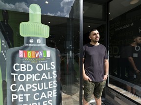 In this photo taken Thursday, March 21, 2019, Gus Dabais stands outside his Sidewalk Wellness store in San Francisco. CBD oil-infused food, drinks and dietary supplements are popular even though the U.S. government says they're illegal and some local authorities have forced retailers to pull products. The confusion has California, Texas and other states moving to legalize the cannabis compound that many see as beneficial to their health.
