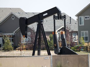 FILE--In this Aug. 16, 2018, file photo, a pump jack works in a recently constructed residential development in Frederick, Colo. On Wednesday, April 3, 2019, the Colorado Legislature gave final approval to a bill that would dramatically change how the state regulates the oil and gas industry, shifting the focus from encouraging production to protecting public health and the environment. The bill now goes to Democratic Gov. Jared Polis, who is expected to sign it.