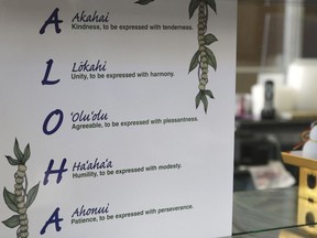 This Tuesday, April 16, 2019 photo shows a sign inside Aloha Poke Shop, a store in Honolulu that received a letter from Chicago-based Aloha Poke Co. saying the Illinois company had trademarked "Aloha Poke" and the Hawaii company would need to change its name. Hawaii lawmakers are considering adopting a resolution calling for the creation of legal protections for Native Hawaiian cultural intellectual property.