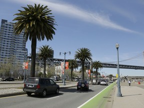 In this photo taken Thursday, April 18, 2019, cars make their way along the Embarcadero, with the San Francisco-Oakland Bay Bridge in the background, across the street from the proposed site of a homeless shelter in San Francisco. The city of San Francisco, which has too little housing and too many homeless people sleeping in the streets, is teeming with anxiety and vitriol these days. A large new homeless shelter is on track to go up along a scenic waterfront area dotted with high-rise luxury condos, prompting outrage from some residents.