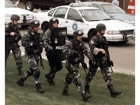 FILE - In this April 20, 1999, file photo, members of a police SWAT team march to Columbine High School in Littleton, Colo., as they prepare to do a final search of the school after two gunmen opened fire on campus. The shooting shocked the country as it played out on TV news shows from coast to coast.