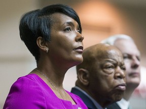 FILE - In this April 8, 2019 file photo, Atlanta Mayor Keisha Lance Bottoms, left, sits with U.S. Congressman John Lewis, second from left, during a tribute to Lewis in the atrium of the domestic terminal at Atlanta's Hartsfield Jackson International Airport. Some students at Spellman College aren't happy about the selection of Atlanta's black woman mayor as this year's commencement speaker. The students at the city's historically black women's college told WSB-TV that they believe Bottoms is in favor of gentrification. The commencement is set for May 19 at the Georgia International Convention Center in Atlanta.