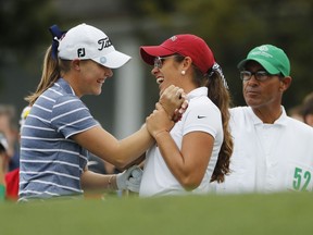 Maria Fassi, of Mexico, right, high-fives Jennifer Kupcho before they tee-off the first hole during the final round of the Augusta National Women's Amateur golf tournament in Augusta, Ga., Saturday, April 6, 2019.