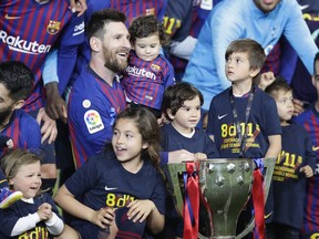 Barcelona forward Lionel Messi with his children pose with the trophy after winning the Spanish League title, at the end of the Spanish La Liga soccer match between FC Barcelona and Levante at the Camp Nou stadium in Barcelona, Spain, Saturday, April 27, 2019. Barcelona clinched the Spanish La Liga title, with three matches to spare, after it defeated Levante 1-0.