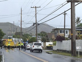 Police and firefighters respond to the scene of a helicopter crash in a residential neighborhood of Kailua, Hawaii, Monday, April 29, 2019. Fire and pieces of helicopter rained from the sky Monday in a suburban Honolulu community in a crash that killed three people aboard, officials and witnesses said.