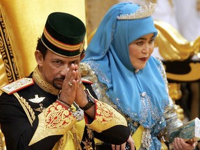 Bruneian Sultan Hassanal Bolkiah (L) greets while Queen Saleha looks on during a ceremony in birthday celebration at his palace in Bandar Seri Begawan, 15 July 2005.