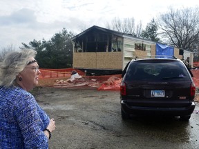 In this Sunday, April 7, 2019 photo, Marie Chockley, a resident of the Timberline Trailer Court, north of Goodfield, Ill., surveys the damage that was caused by a Saturday night fire that killed five residents in a mobile home.