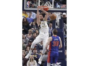 Indiana Pacers' Domantas Sabonis (11) dunks as Detroit Pistons' Jon Leuer (30) watches during the first half of an NBA basketball game, Monday, April 1, 2019, in Indianapolis.