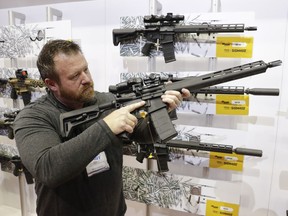 Bryan Oberc, Munster, Ind., tries out an AR-15 from Sig Sauer in the exhibition hall at the National Rifle Association Annual Meeting in Indianapolis, Saturday, April 27, 2019.