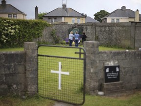 In this June 7, 2014 file photo members of the public are seen at the site of a mass grave for children who died in the Tuam mother and baby home, in Tuam, County Galway, Ireland.