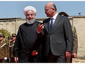 FILE - In this March 11, 2019 file photo, Iraqi President Barham Salih, right, walks with visiting Iranian President Hassan Rouhani, before their meeting at Salam Palace in Baghdad, Iraq. Iraq is seeking to reclaim a leadership role in the Arab world after decades of conflict. It is focusing on a centrist policy and its top leaders are determined to maintain good relations with both Iran and the United States.
