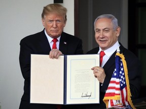 In this March 25, 2019 file photo, Israeli Prime Minister Benjamin Netanyahu and President Donald Trump hold up the signed proclamation recognizing Israel's sovereignty over the Golan Heights at the White House in Washington. In a tight race for re-election, Netanyahu has gotten a welcome lift from his friend in the White House.