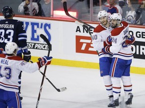 Montreal Canadiens' Jordan Weal (43), Joel Armia (40) and Phillip Danault (24) celebrate ArmiaÕs goal on the Winnipeg Jets as Dustin Byfuglien (33) skates by during first period NHL action in Winnipeg on Saturday, March 28, 2019.