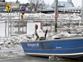 A Beauceville rescue boat sits on the parking of a strip mall by the flooded main road in Beauceville Que.
