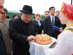 In this Wednesday, April 24, 2019, photo, North Korean leader Kim Jong Un, center, receives bread and salt on his arrival at Khasan train station, Primorsky Krai region, Russia. The content of this image is as provided and cannot be independently verified. (Korean Central News Agency/Korea News Service via AP)