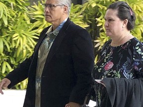 FILE - In this March 4, 2019 file photo, former Honolulu police chief Louis Kealoha and his wife, former deputy prosecutor Katherine Kealoha, hold hands while walking into the U.S. courthouse in Honolulu. Prosecutors say the couple funded a lavish lifestyle by defrauding banks, relatives and children. They're heading to trial in May 2019 on charges they orchestrated the framing of a relative for a mailbox theft who threatened to expose their fraud.
