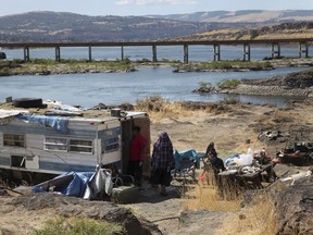FILE - This Aug. 22, 2014, file photo shows the home of Ranetta Spino and her family at the river's edge at Lone Pine, a Native American fishing site on the Columbia River near The Dalles, Ore. Federal legislation to assess 31 tribal fishing sites in Oregon and Washington and make critical improvements to sewer and water systems has passed the U.S. House after three years of delays.