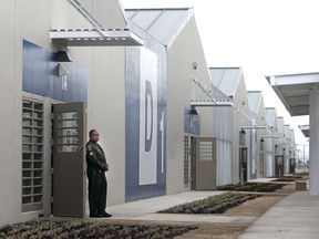 FILE - In this June 25, 2013 file photo, a correctional officer stands outside of one of the secure housing units at the new California Correctional Health Care Facility in Stockton, Calif., during dedication day festivities. Legionnaires' disease bacteria that killed one inmate and sickened another is more widespread than expected in a California state prison, officials said Wednesday, April 17, 2019, citing new test results. Preliminary results found the bacteria in the water supply at a prison medical facility in Stockton and at two neighboring youth correctional facilities, said Corrections Department spokeswoman Vicky Waters.