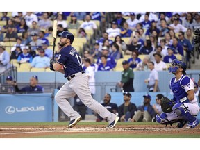Milwaukee Brewers' Mike Moustakas watches his solo home run next to Los Angeles Dodgers catcher Austin Barnes during the second inning of a baseball game Saturday, April 13, 2019, in Los Angeles.