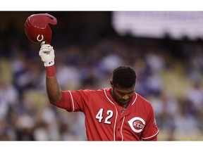 Cincinnati Reds' Yasiel Puig tips his helmet to fans as he comes up to bat during the first inning of a baseball game against the Los Angeles Dodgers, Monday, April 15, 2019, in Los Angeles.