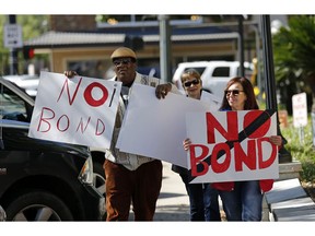 Wilfred Young, Agnes Courbille, center, and Karel Anne Zibe, right, of the St. Landry Parish branch of the NAACP, carry signs outside the St. Landry Parish courthouse after a bond hearing for Holden Matthews in Opelousas, La., Monday, April 15, 2019. Matthews, who is white, and is the son of a St. Landry Parish sheriff's deputy, was arrested Wednesday on three charges of arson of a religious building, and is the suspect in three recent arson fires that destroyed African American churches in Louisiana.