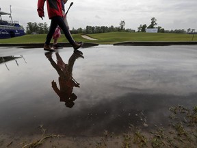 People walk on the largely empty course during a weather delay for the first round of the PGA Zurich Classic golf tournament at TPC Louisiana in Avondale, La., Thursday, April 25, 2019.