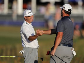 John Rahm, right, celebrates with teammate Ryan Palmer after sinking a birdie putt on the 18th green to tie the lead on their last shot for the day during the third round of the PGA Zurich Classic golf tournament at TPC Louisiana in Avondale, La., Saturday, April 27, 2019.