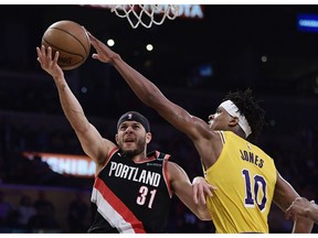Portland Trail Blazers guard Seth Curry, left, shoots as Los Angeles Lakers forward Jemerrio Jones defends during the first half of an NBA basketball game Tuesday, April 9, 2019, in Los Angeles.